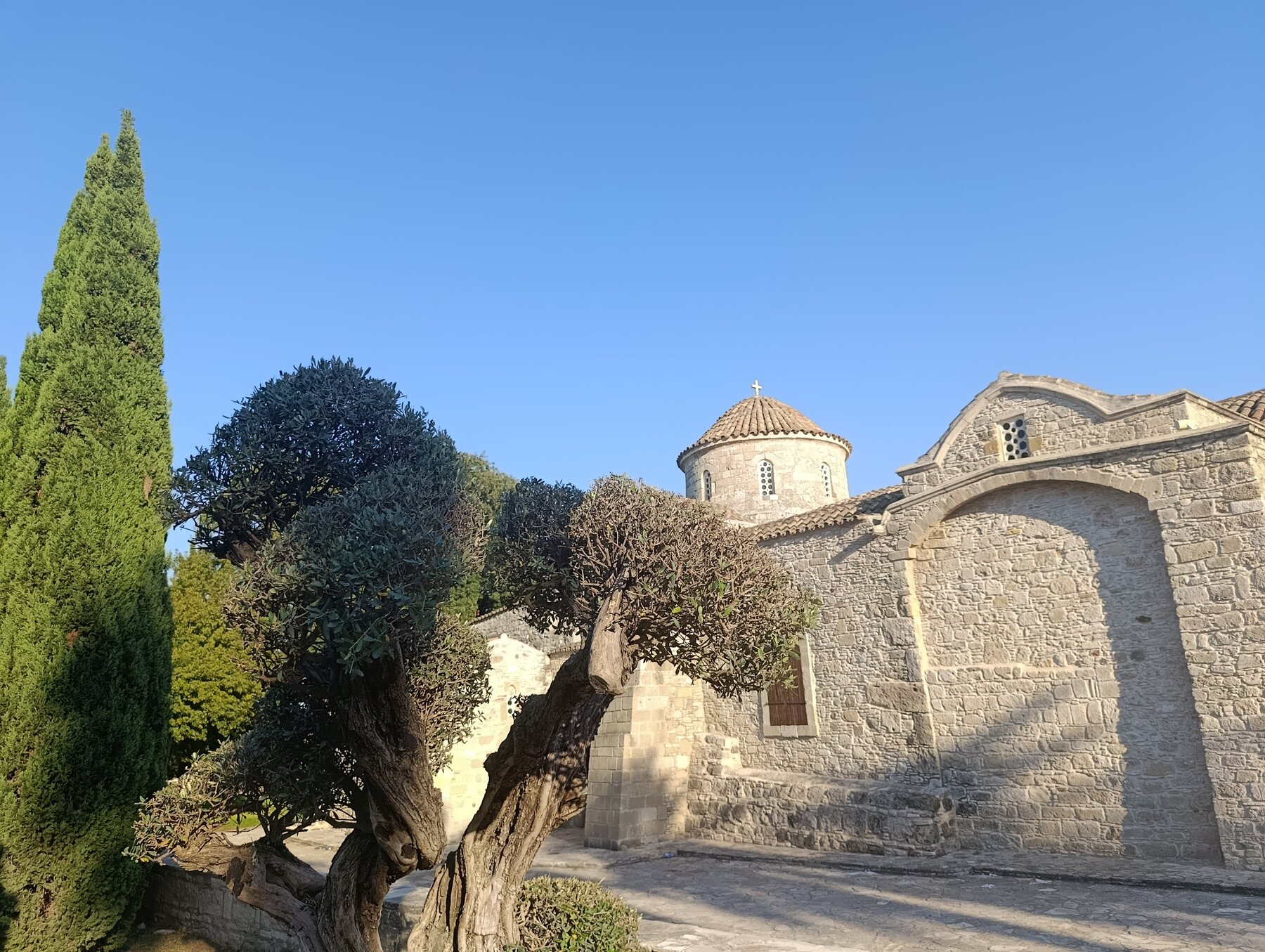 Ancient stone church of Panagia Angeloktisti framed by mature trees